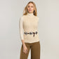 Model wearing a Brighton leather belt with three silver-tone concho medallions over a cream cable-knit top