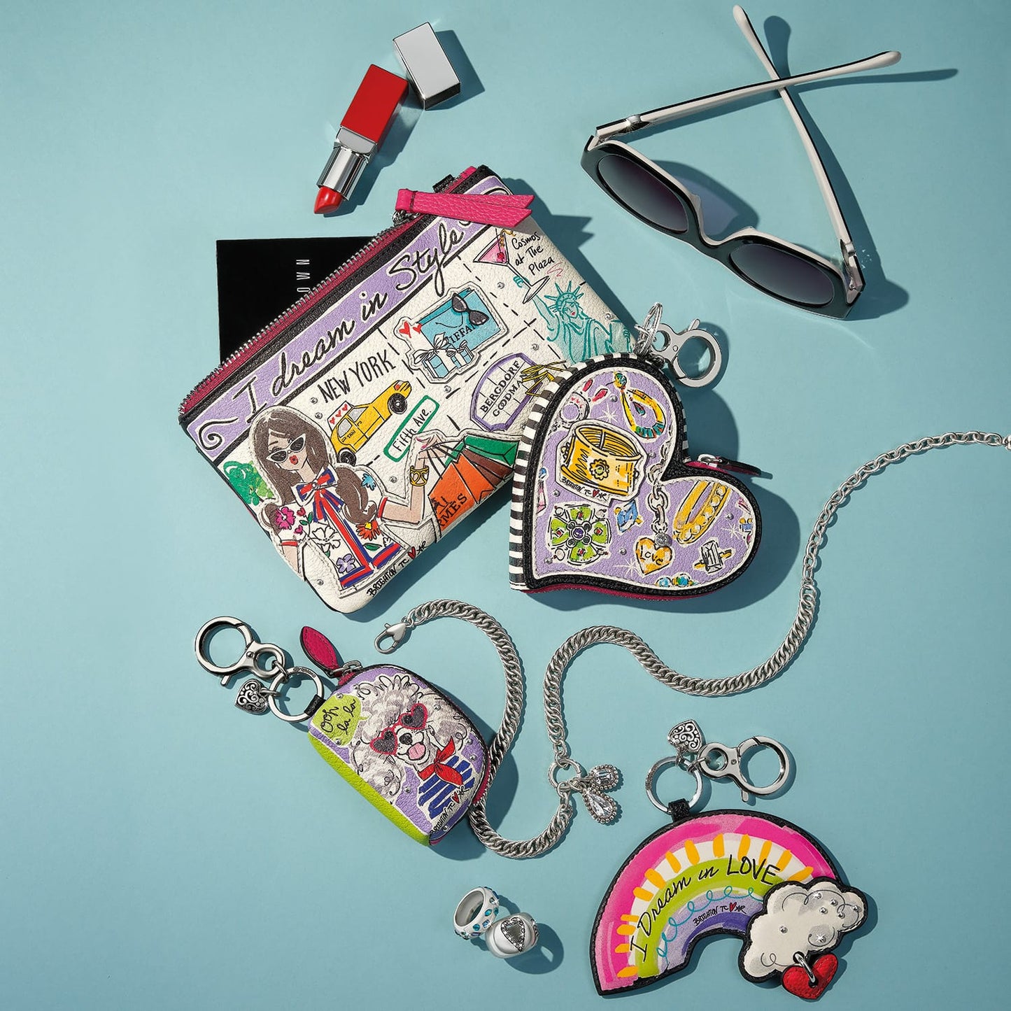 Brighton leather pouch with illustrated New York print, styled with heart and rainbow charms and other accessories