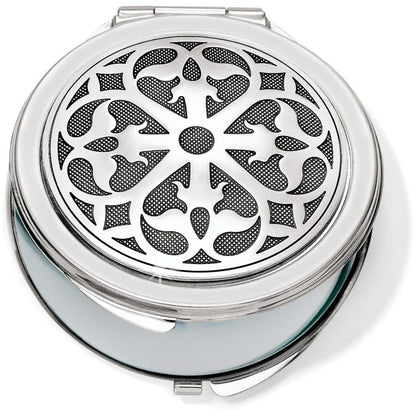 Brighton compact mirror with round silver-tone lid featuring ornate scrollwork medallion design on a white background