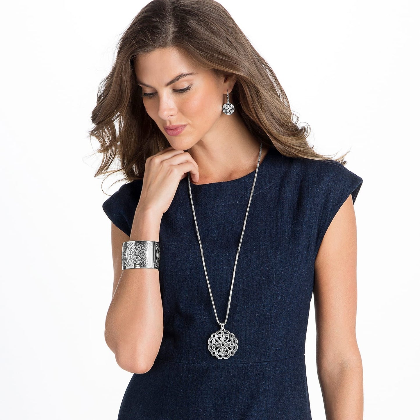 Model wearing a Brighton silver-plated pendant necklace with openwork medallion and coordinating Brighton accessories