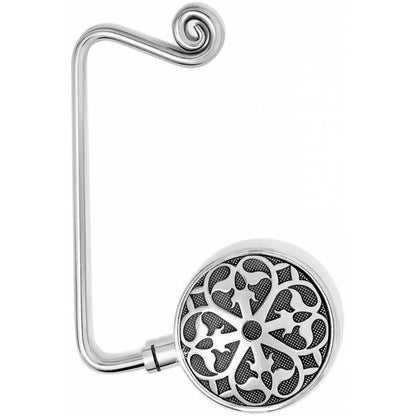 Brighton purse hook with silver-tone curled hook and round medallion featuring ornate floral scrollwork on a white background