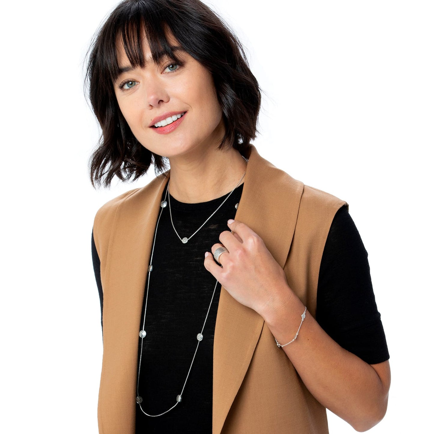Model wearing a Brighton long silver-plated station necklace with round medallions and coordinating Brighton accessories