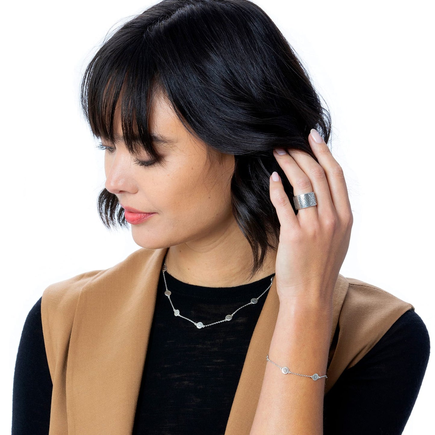 Model wearing a Brighton silver-plated wide band ring with engraved detail and coordinating Brighton necklace and bracelet