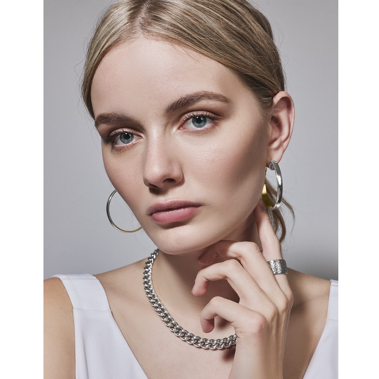 Model wearing Brighton silver-plated hoop earrings with coordinating Brighton chain necklace and engraved band ring