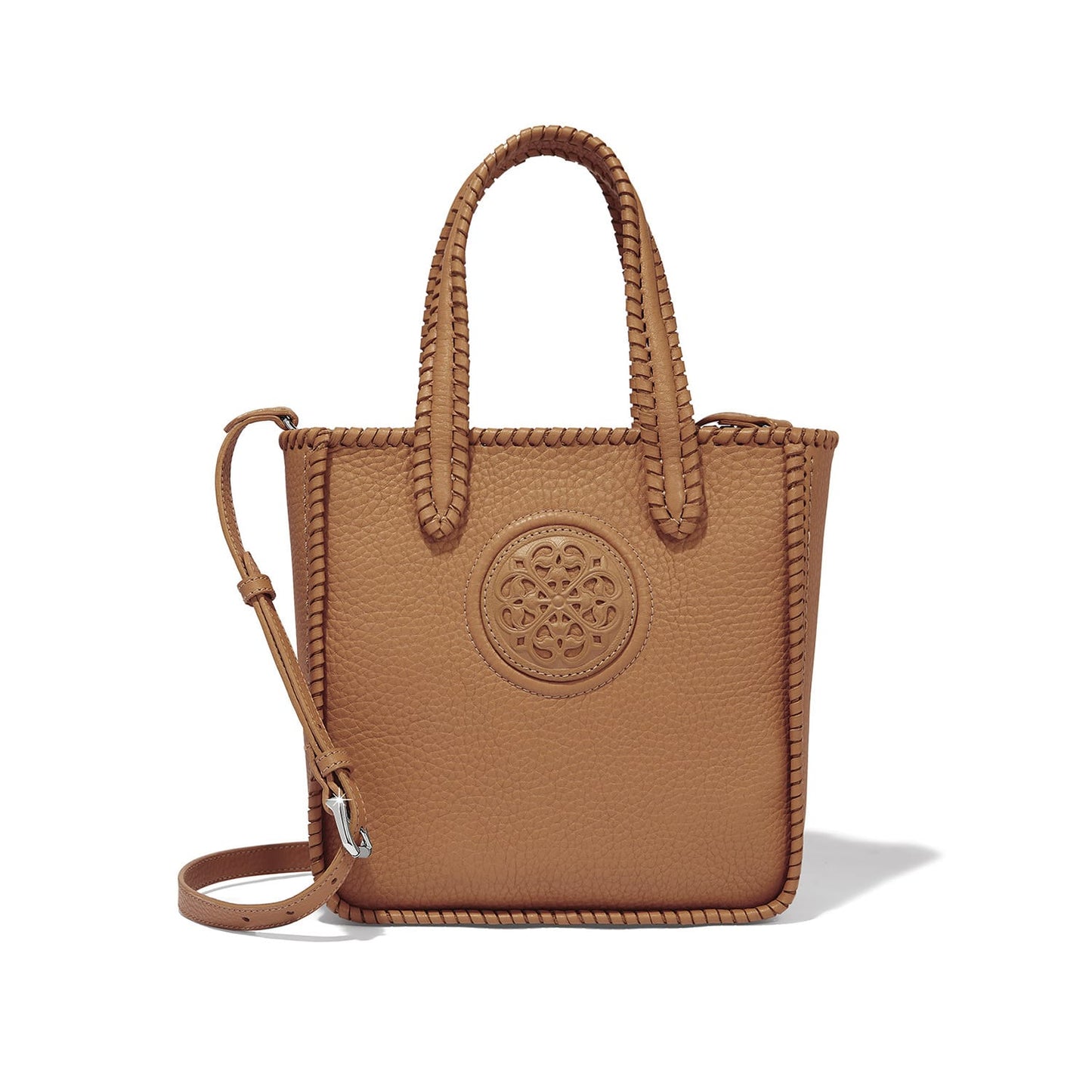 Brighton tote handbag in tan leather with whipstitched edges, embossed medallion, and crossbody strap on a white background