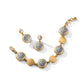 Brighton bracelet and drop earrings with silver-plated filigree medallions and brushed gold-plated discs on a white background