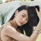 Model wearing Brighton silver and gold drop earrings with coordinating Brighton bracelets and holding a black embossed wallet