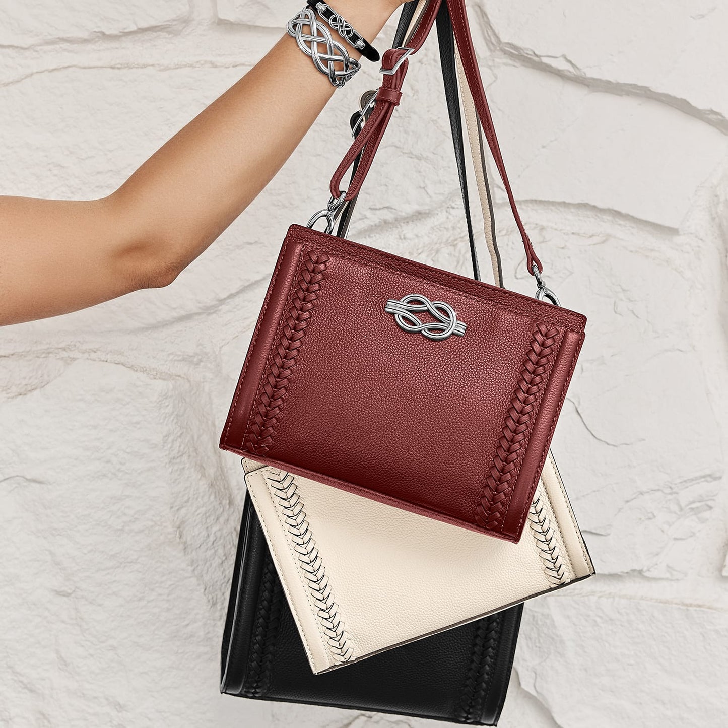 Brighton handbags in burgundy, ivory, and black leather with braided trim and silver-tone knot hardware
