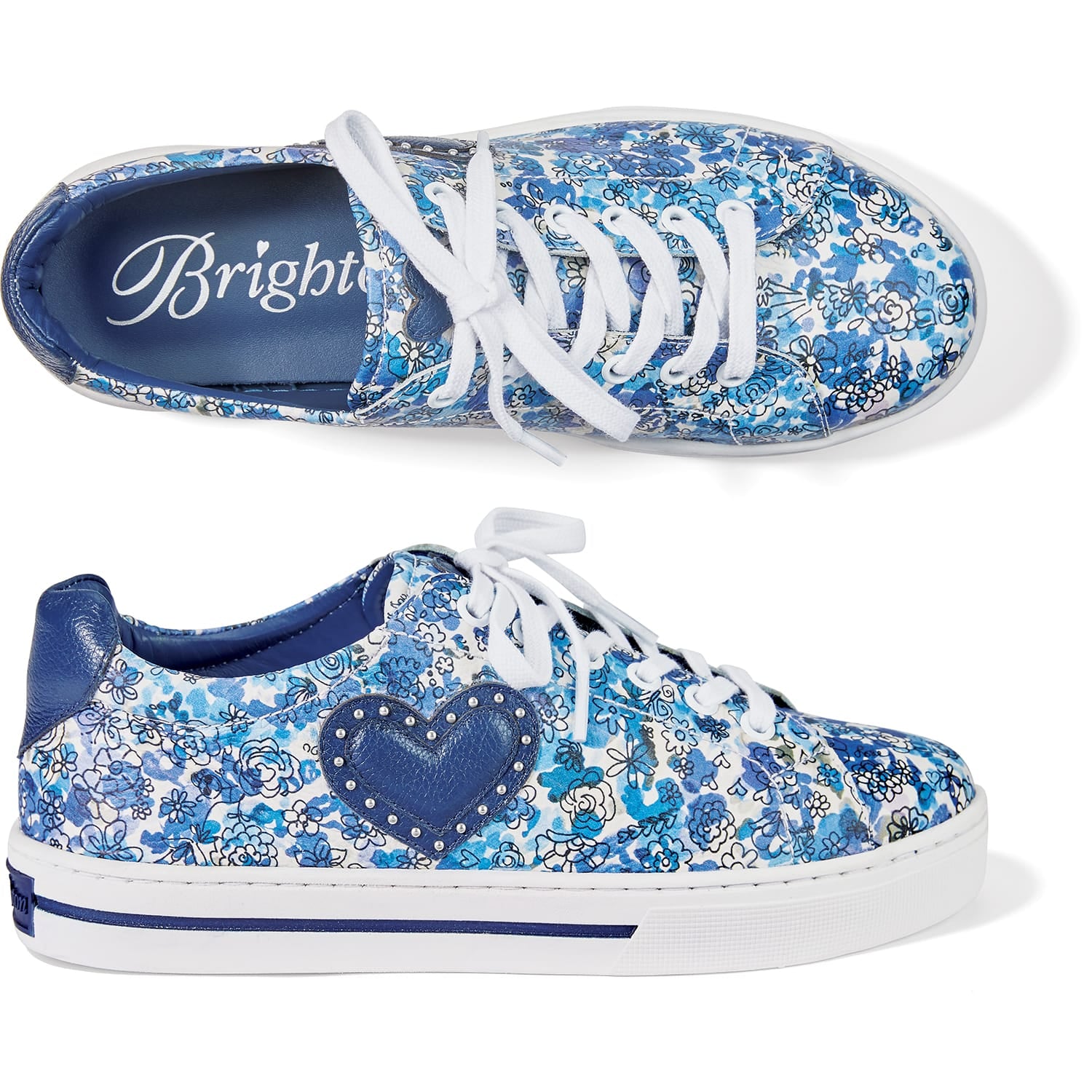 Brighton leather sneakers with blue floral print, navy heart appliqué, studded accents, and white laces on a white background