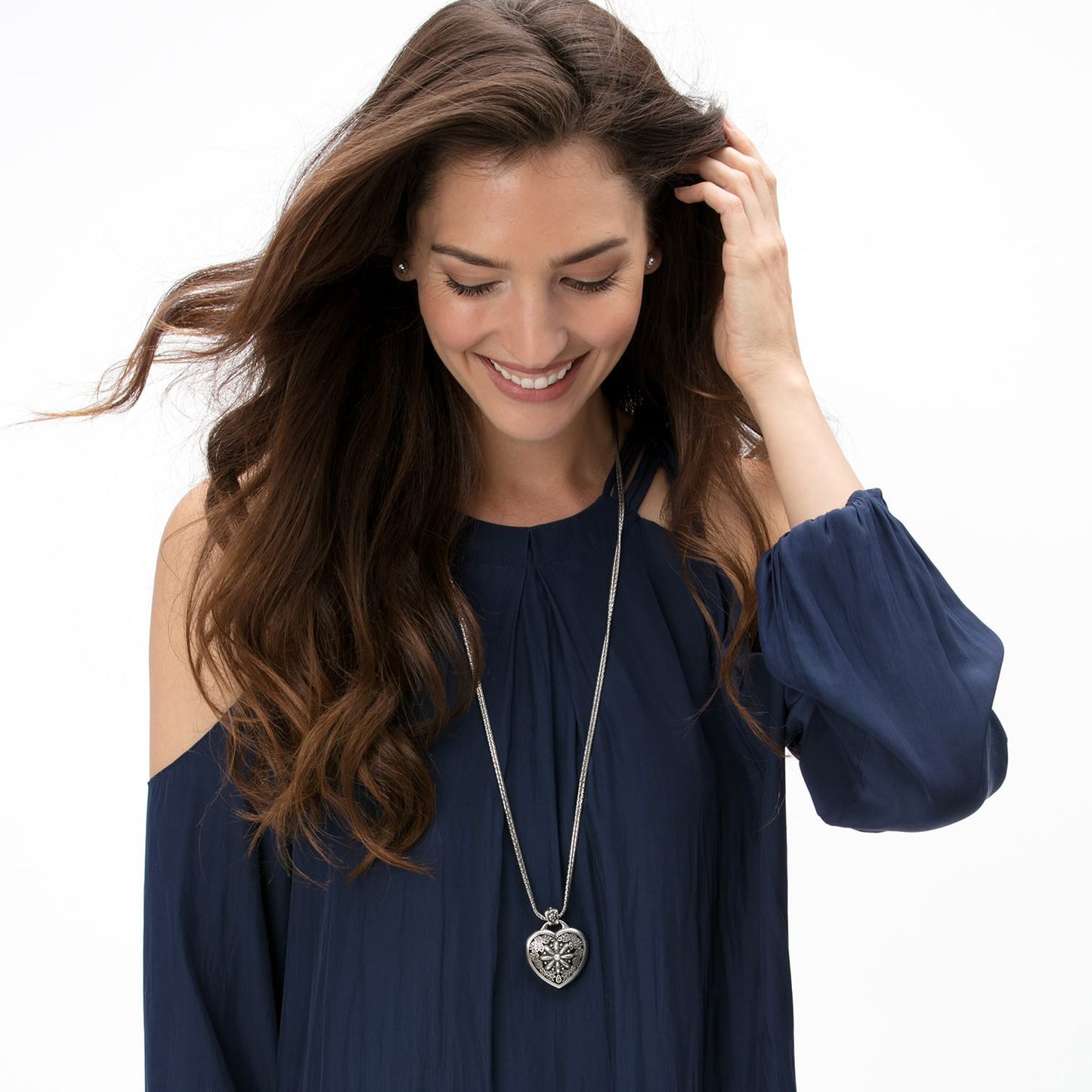 Model wearing a Brighton silver-plated pendant necklace with ornate heart charm on long chain.