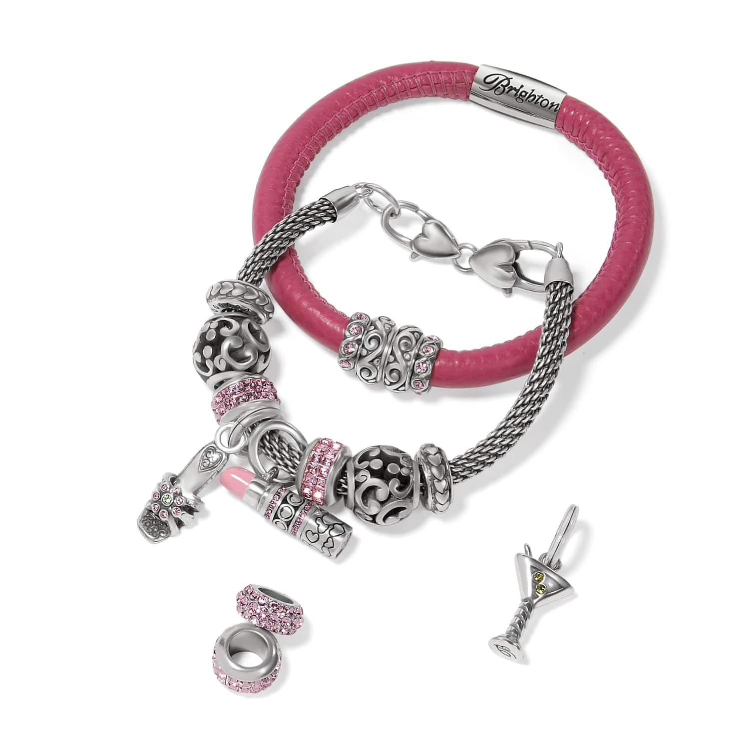 Brighton charm bracelets styled with silver-plated charms, pink crystal beads, and enamel accents on a white background
