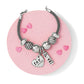 Brighton silver-plated beaded charm bracelet styled with heart and love charms on a pink background