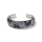 Brighton silver-tone cuff bracelet with blue and clear crystals in floral pattern and black lacquer on a white background