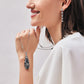 Model wearing a Brighton silver-plated crystal pendant necklace with blue teardrop pendant and coordinating Brighton accessories