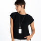 Model wearing a Brighton long silver-plated chain necklace with rectangular white pendant and decorative circular accent