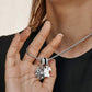 Model wearing a Brighton silver-plated necklace with spiderweb charm, white enamel ghost, and crystal accents