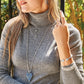 Model wearing a Brighton silver-plated heart pendant necklace with blue crystals and coordinating Brighton accessories