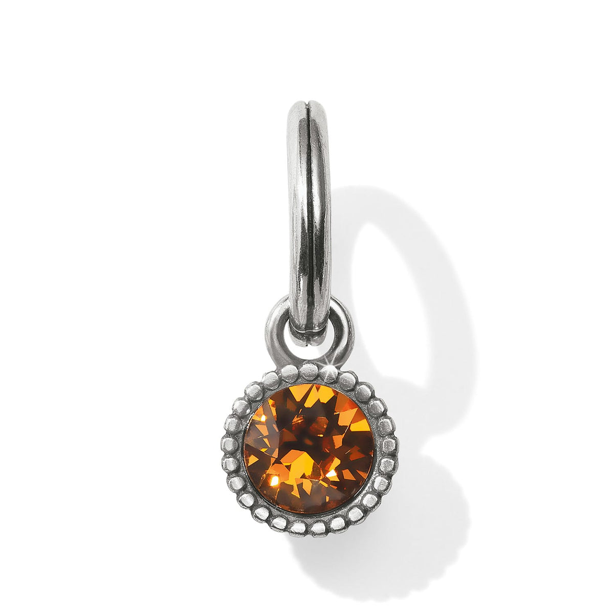 Brighton charm with round amber crystal, beaded silver-tone bezel, and hinged clip closure on a white background