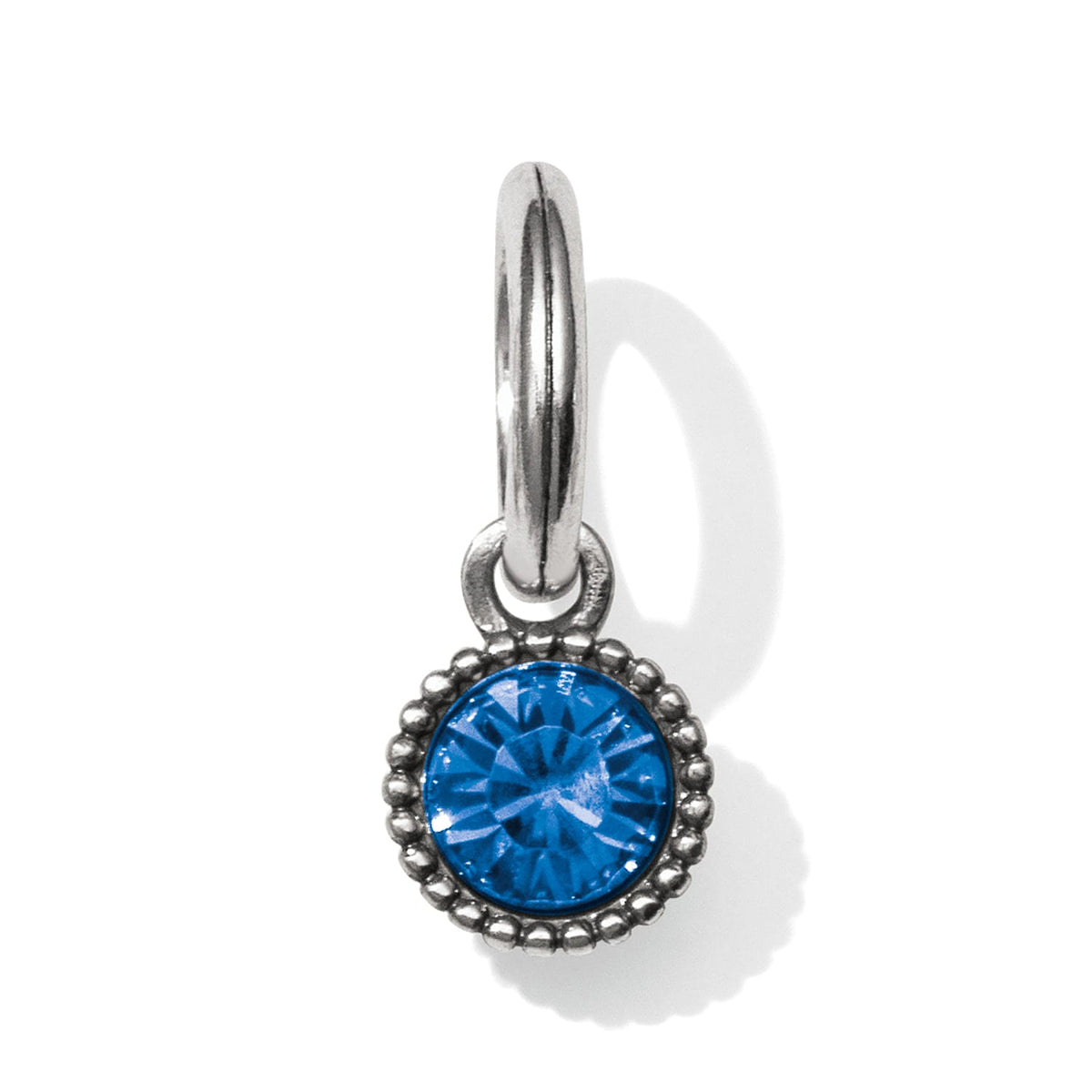 Brighton charm with round blue crystal and silver-tone beaded border on a hinged ring on a white background