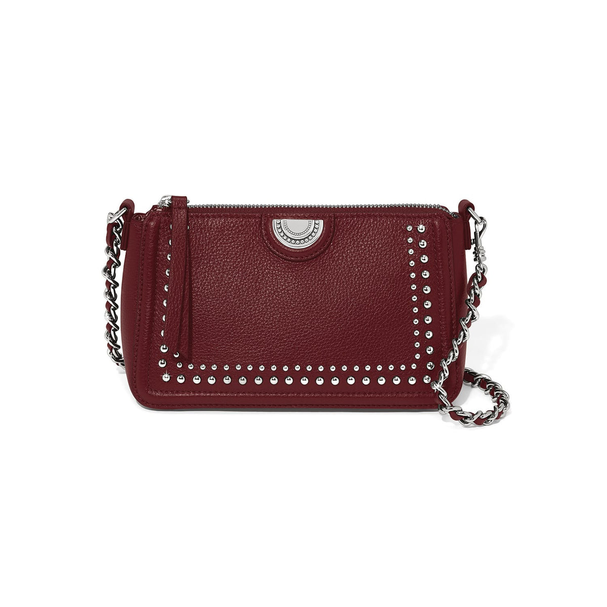 Brighton burgundy leather crossbody handbag with silver-tone studs, medallion accent, and woven chain strap on a white background