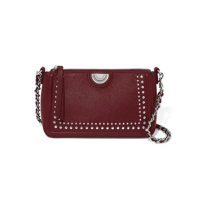 Brighton burgundy leather crossbody handbag with silver-tone studs, medallion accent, and woven chain strap on a white background