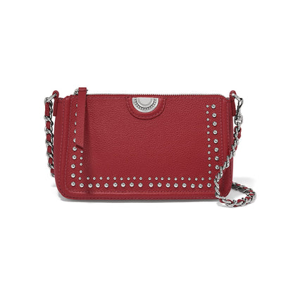 Brighton red leather crossbody handbag with silver-tone studs, medallion accent, and woven chain strap on a white background