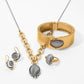 Brighton jewelry set styled with gold-plated hinged bangle, chain necklace, drop earrings, and matching ring with gray faceted stones