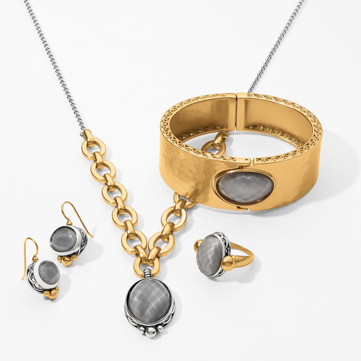 Brighton jewelry set styled with gold-plated hinged bangle, chain necklace, drop earrings, and matching ring with gray faceted stones