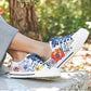 Model wearing Brighton white leather sneakers with floral print, blue laces, and Love script side detail