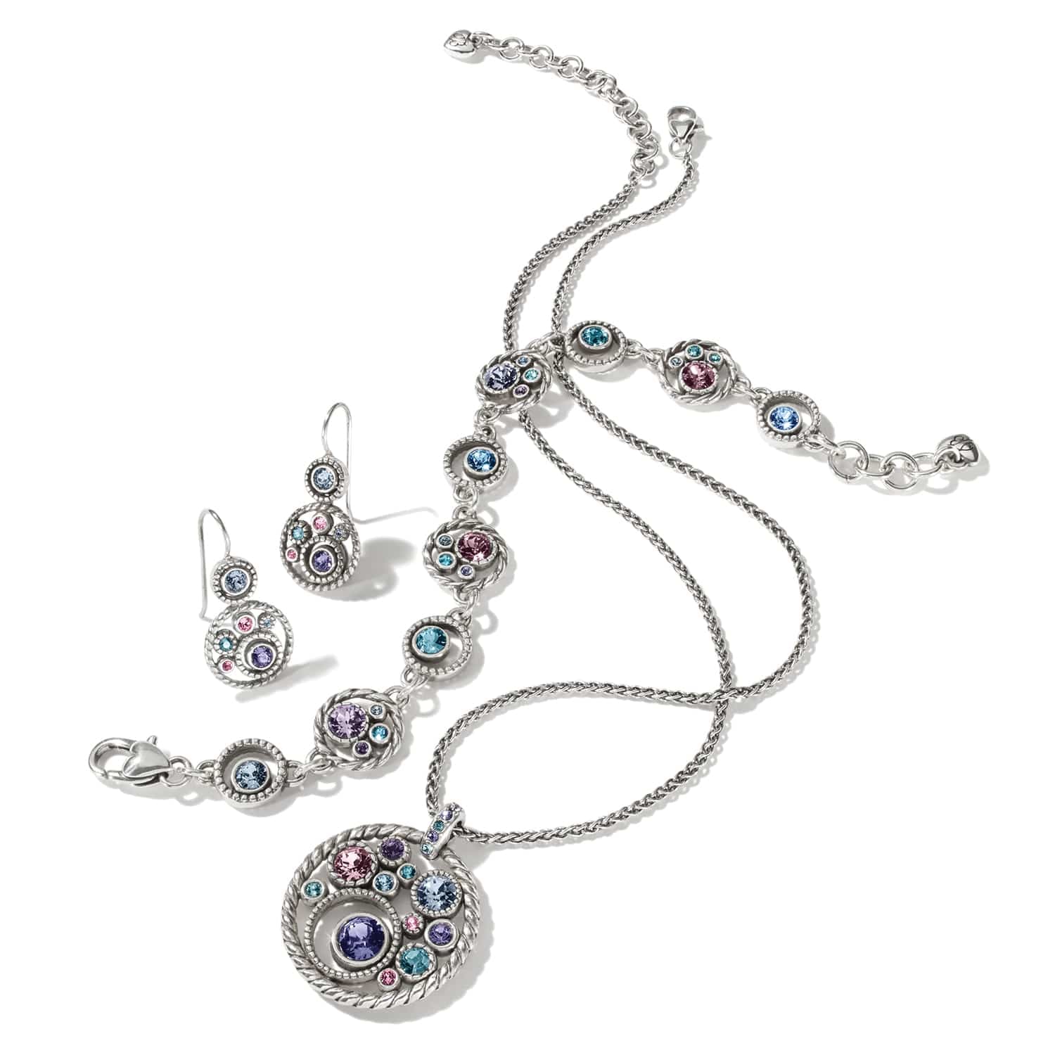 Brighton silver-plated necklace, bracelet, and earrings set styled together with multicolored crystal accents on a white background