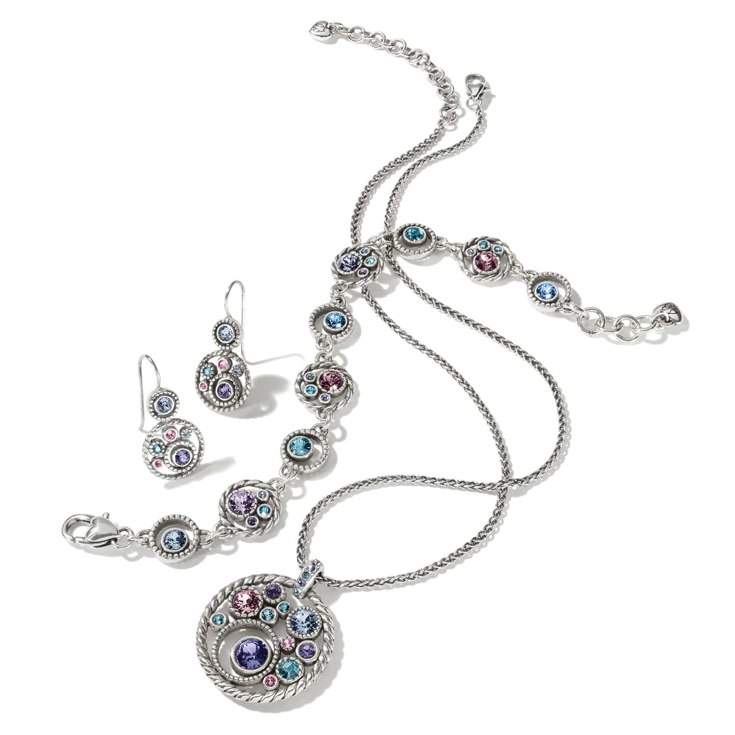 Brighton silver-plated necklace, bracelet, and earrings set styled together with multicolored crystal accents on a white background