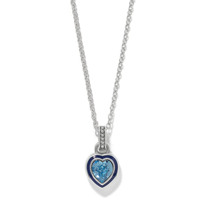 Brighton pendant necklace with blue crystal heart, navy enamel border, and silver-plated chain on a white background