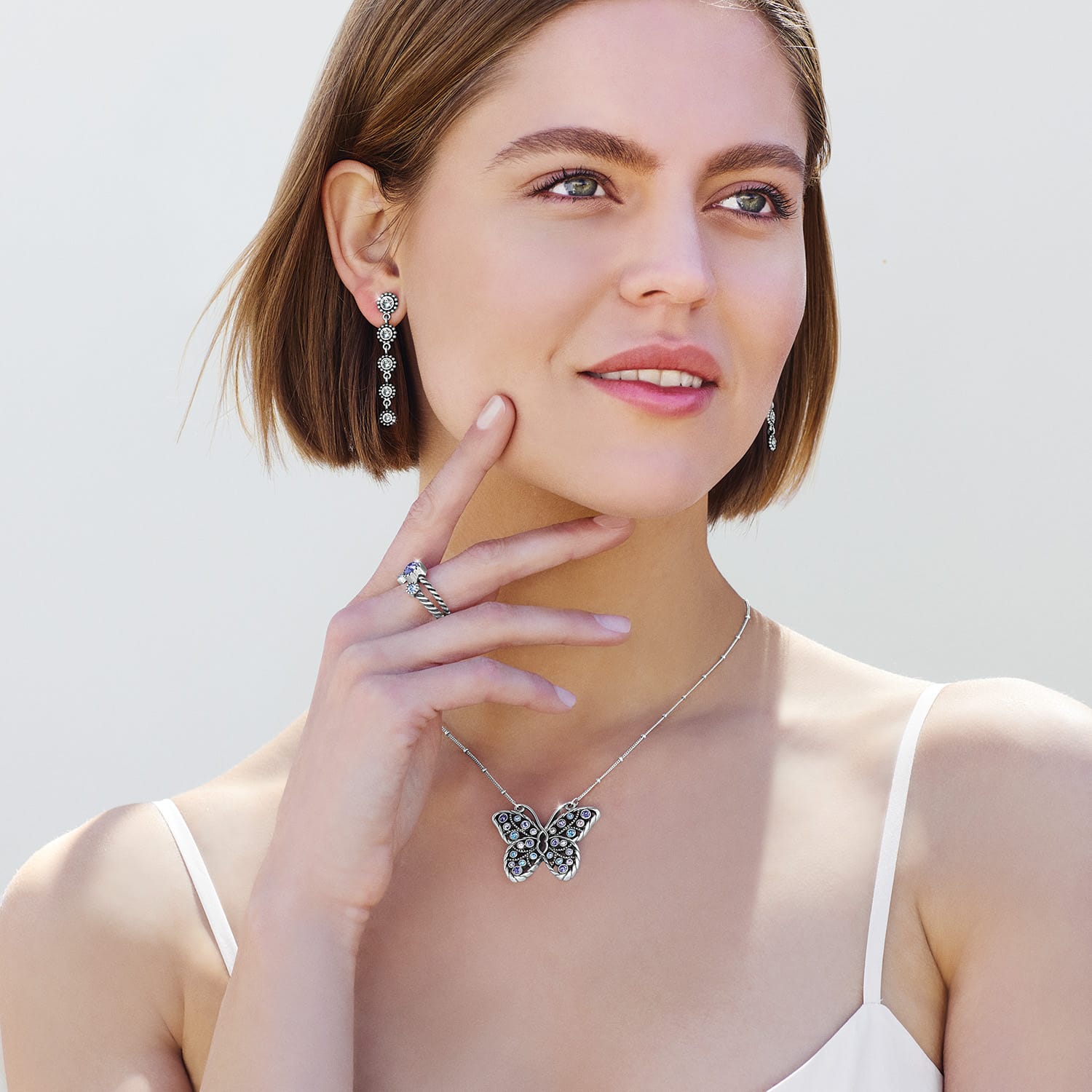 Model wearing a Brighton silver-plated butterfly pendant necklace with crystal accents and coordinating Brighton accessories