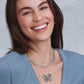 Model wearing Brighton silver-plated layered necklaces with chain links and a crystal butterfly pendant