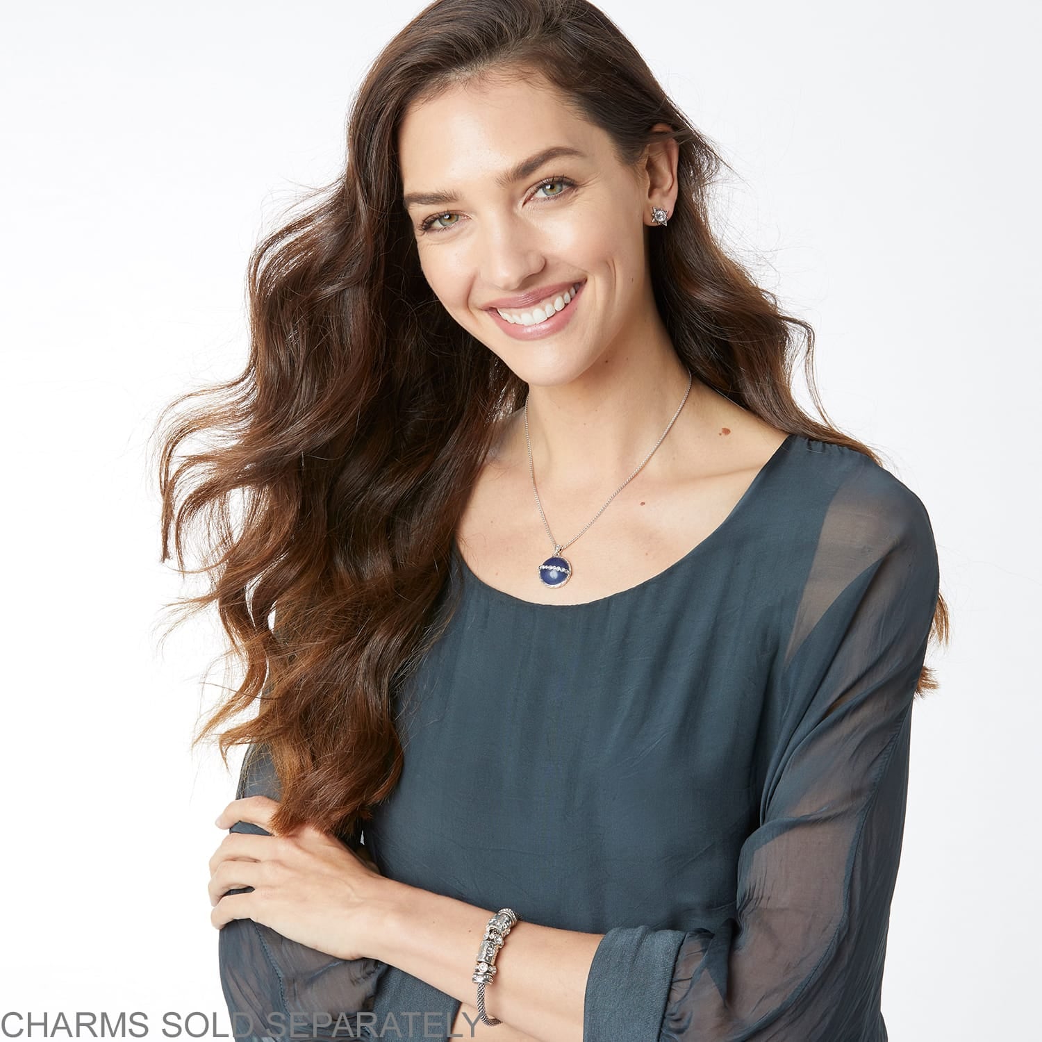 Model wearing a Brighton silver-plated pendant necklace with blue stone and coordinating Brighton accessories