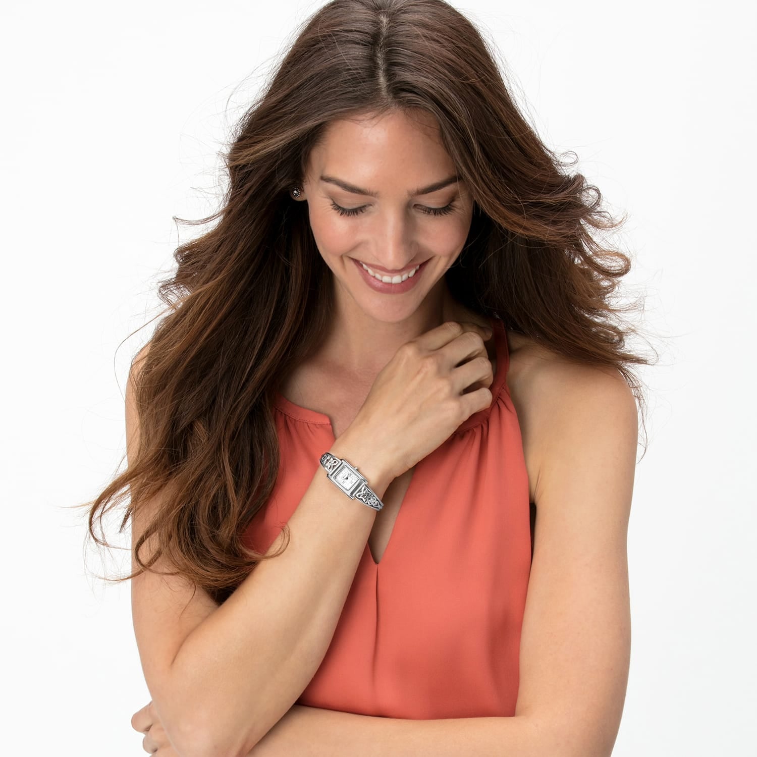 Model wearing a Brighton silver-plated watch with rectangular dial and decorative scrollwork band on wrist