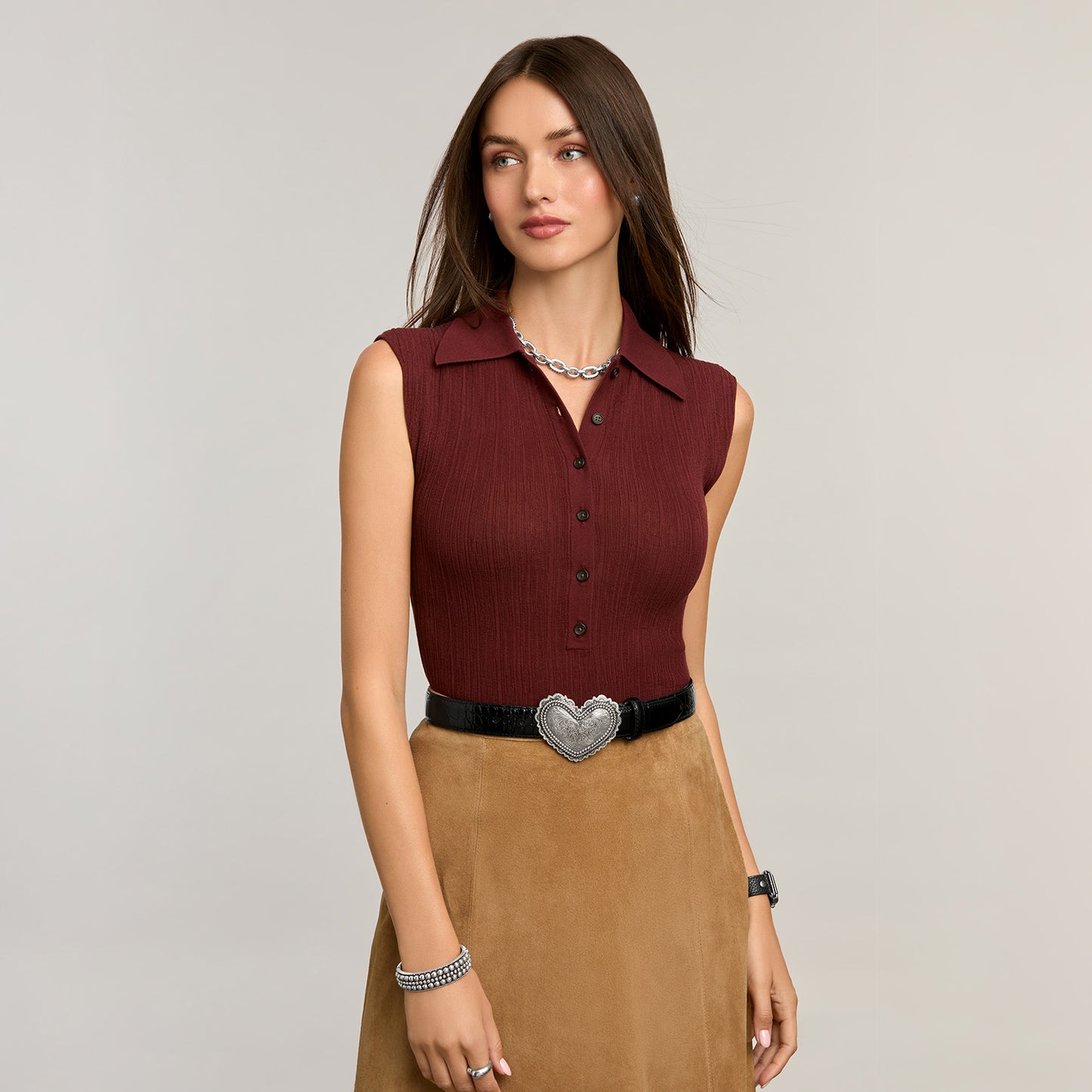 Model wearing a Brighton black leather belt with ornate silver-tone heart-shaped buckle, styled with coordinating Brighton accessories