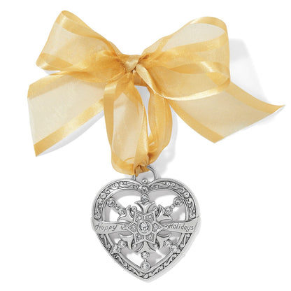 Brighton silver-plated heart ornament with crystal snowflake, Happy Holidays engraving, and gold organza bow on a white background