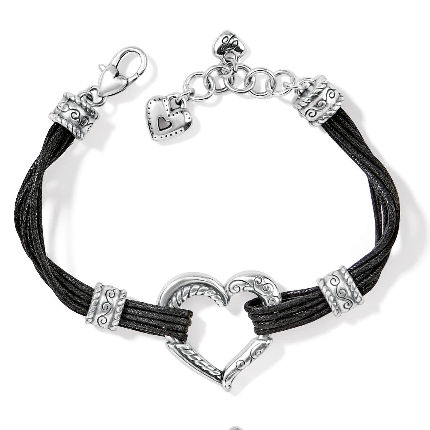 Brighton bracelet with black cord strands, silver-plated heart centerpiece, scroll accents, and heart charm on a white background
