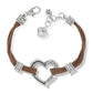 Brighton bracelet with brown cord strands, silver-plated heart centerpiece, scrollwork spacers, and heart charm on a white background