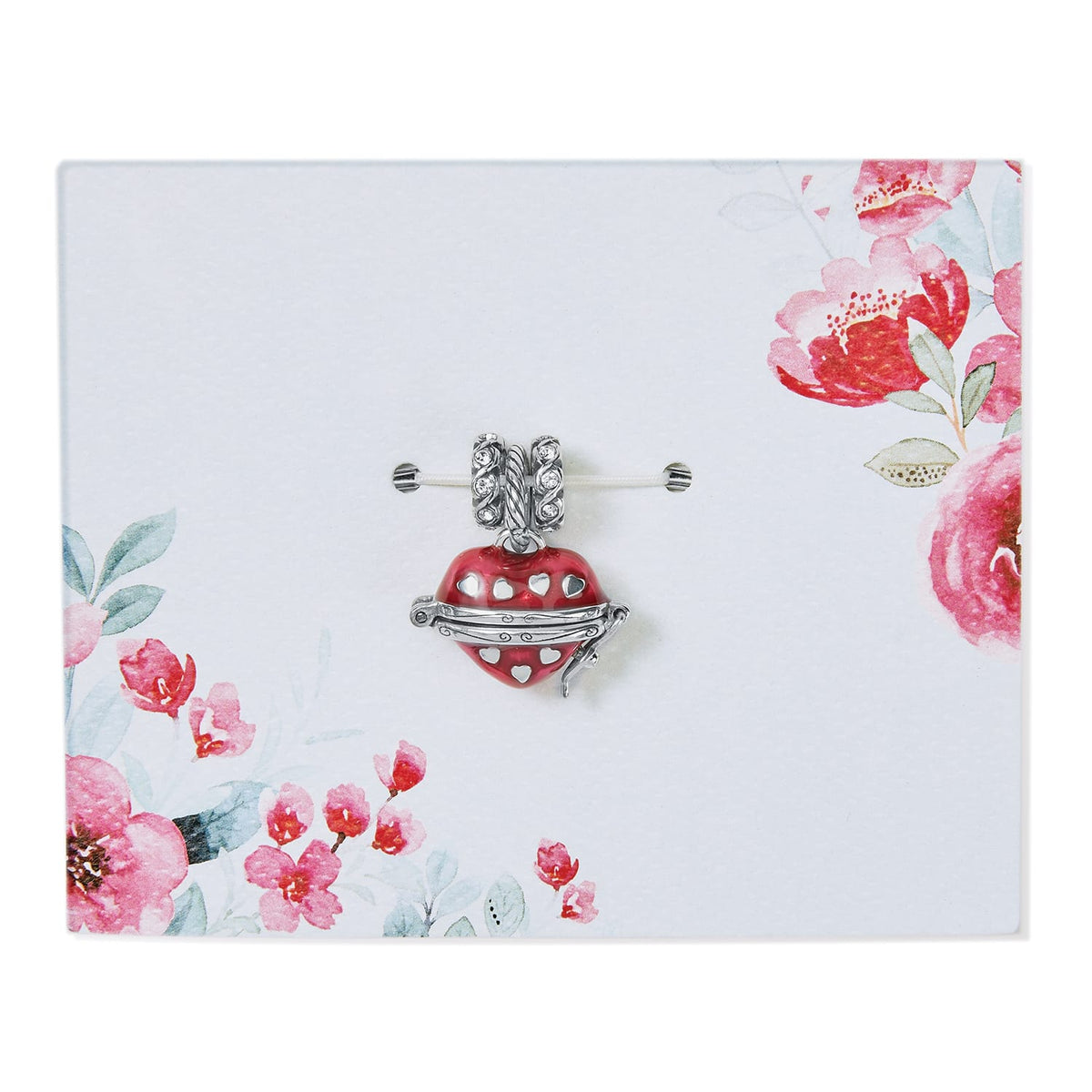 Brighton heart locket charm in red enamel with silver-plated cutout hearts and crystal bail on floral card