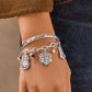 Model wearing a Brighton silver-plated bangle with holiday charms, red crystals, and glass pearl accents