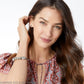 Model wearing a Brighton silver-plated charm bracelet with ornate beads and crystal accents on woven band