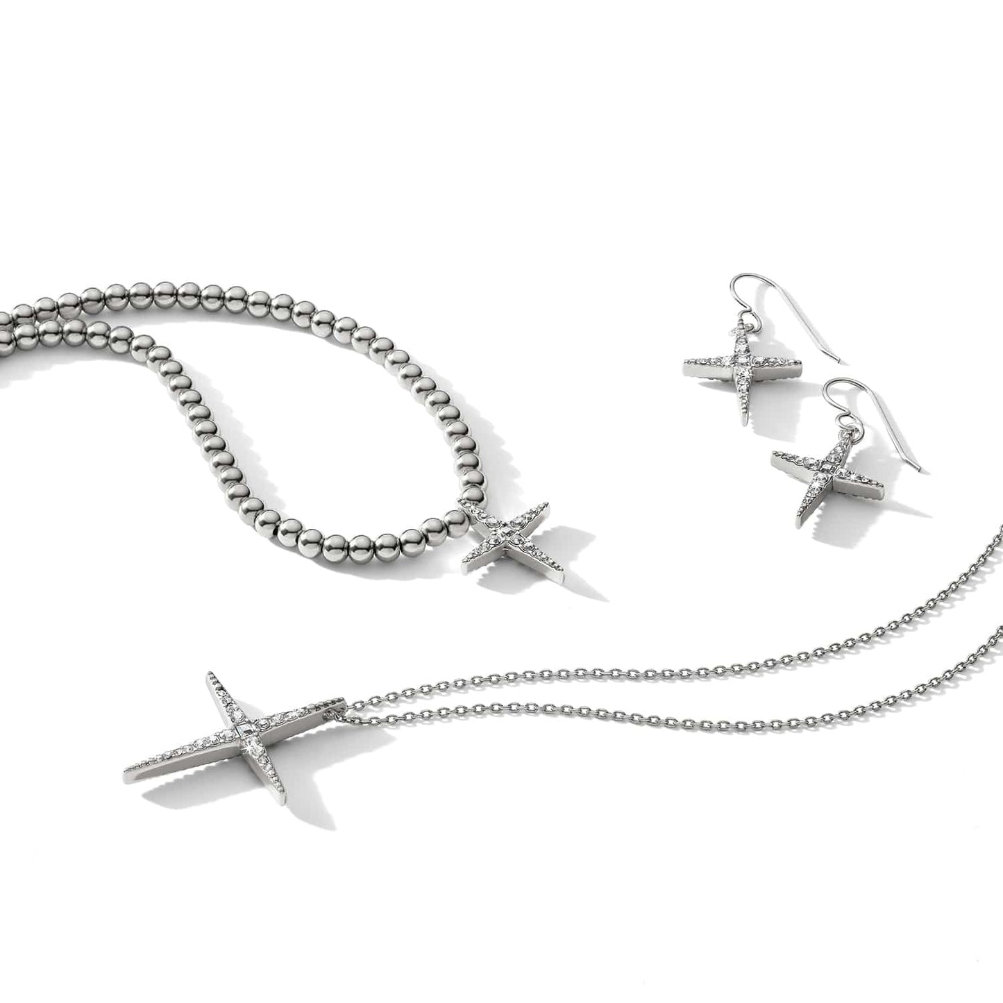 Brighton silver-plated cross jewelry set styled with beaded bracelet, drop earrings, and chain pendant necklace with crystals