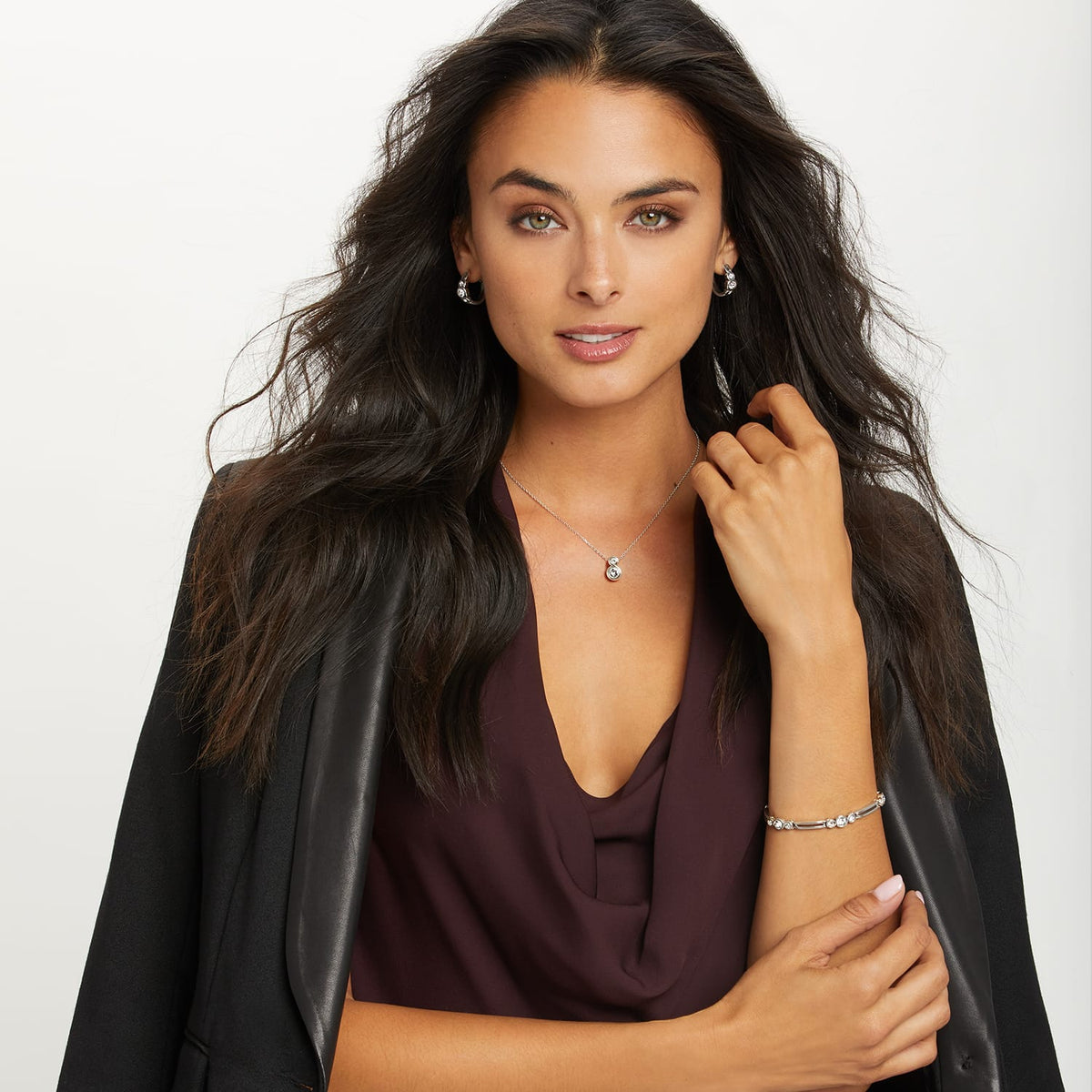 Model wearing a Brighton silver-plated pendant necklace with crystal accent and coordinating Brighton earrings and bracelet