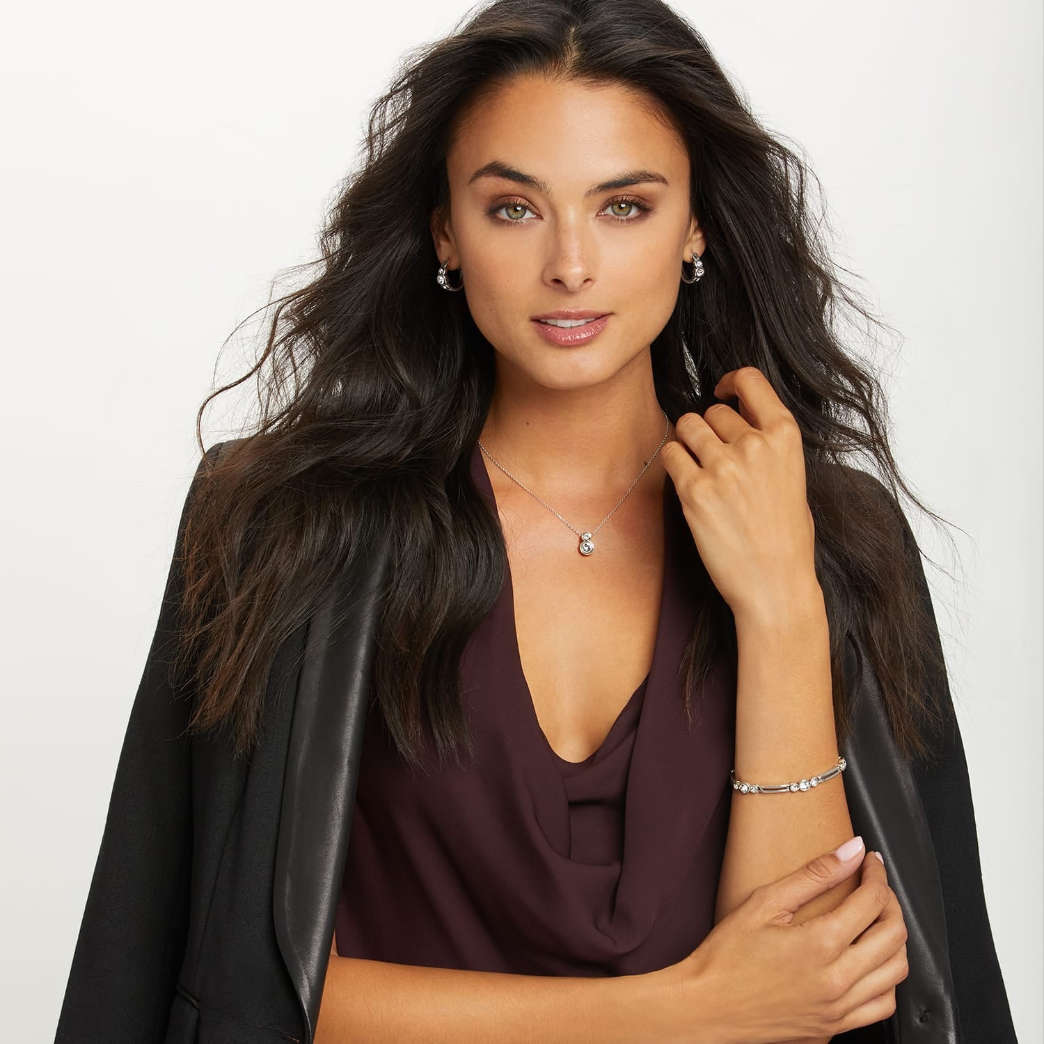 Model wearing a Brighton silver-plated pendant necklace with crystal accent and coordinating Brighton hoop earrings and bracelet