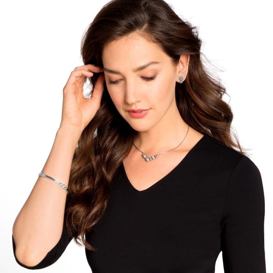 Model wearing a Brighton silver-plated necklace with crystal accents paired with matching stud earrings and bracelet