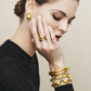 Model wearing Brighton gold-plated hammered earrings and stacked rings with coordinating gold-plated bangles and hinged bracelets
