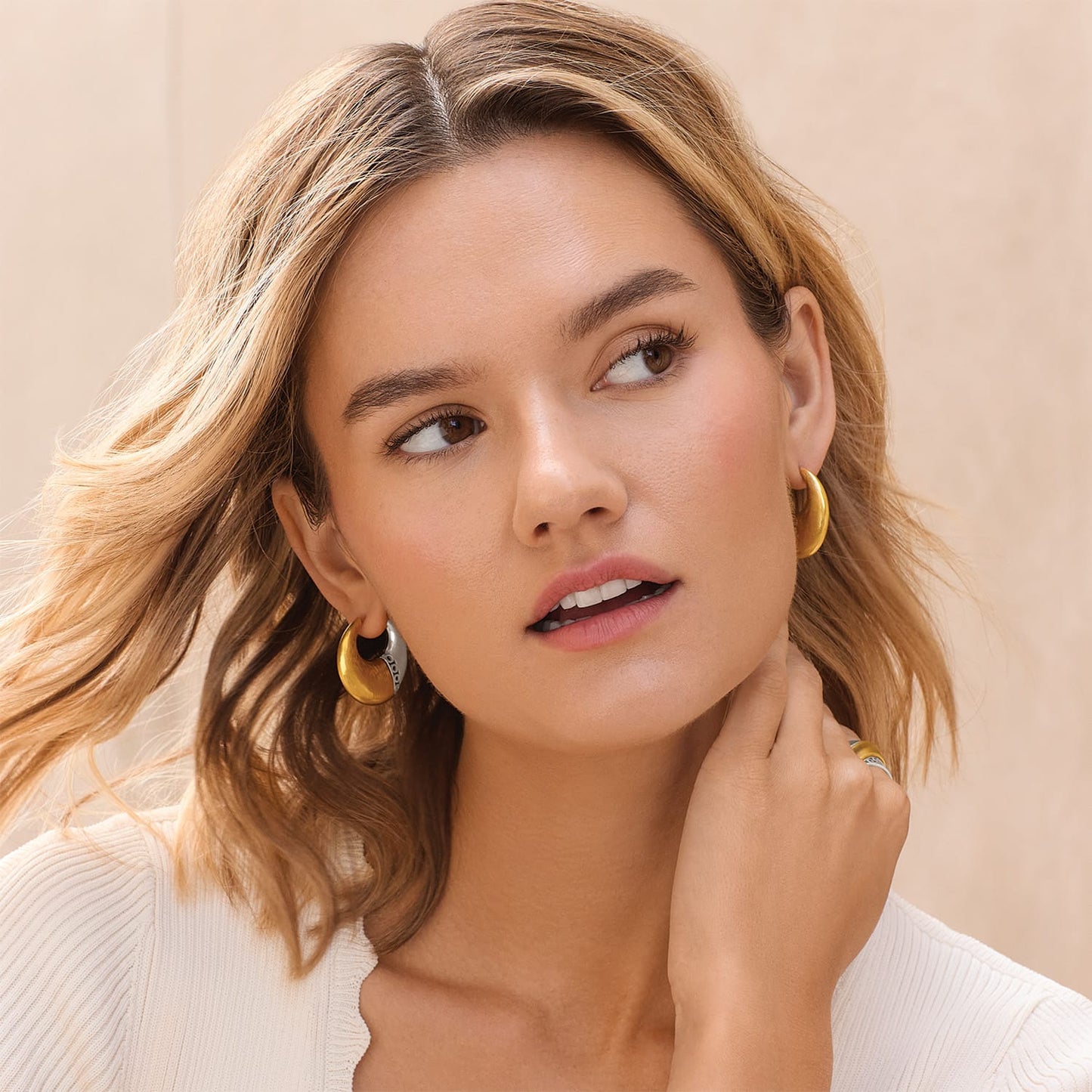 Model wearing Brighton two-tone hoop earrings with gold and silver finish and a coordinating Brighton ring