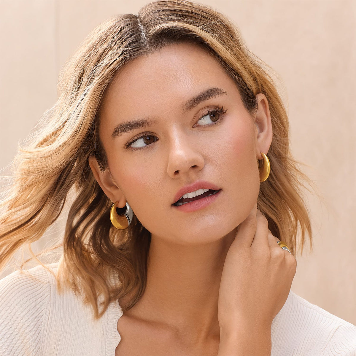 Model wearing Brighton two-tone hoop earrings with gold and silver finish and a coordinating Brighton ring
